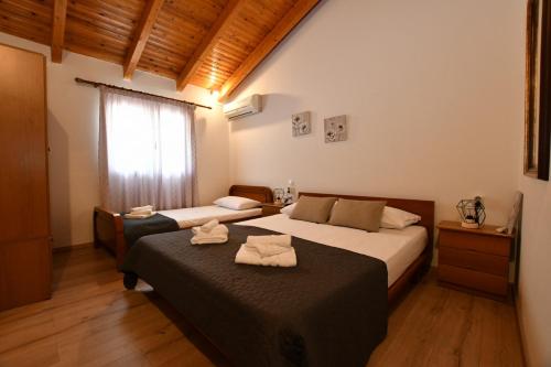 a bedroom with two beds and a window at DownTown Loft in Aígio