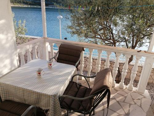 a table and chairs on a balcony with a view of the water at Apartmani Villa Anita in Neum