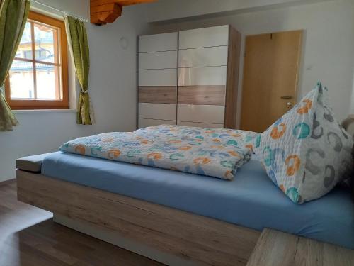 a bed with a blue mattress and two pillows at Nagelehof 3 in Ainet