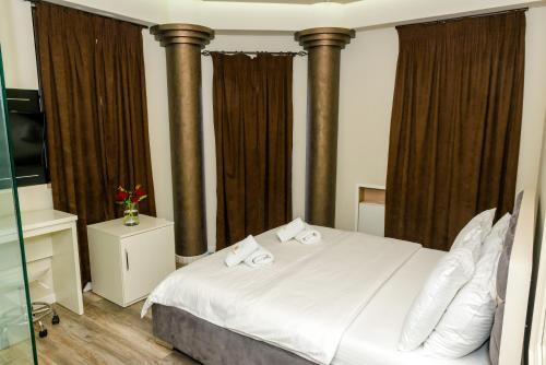 een slaapkamer met een bed met twee handdoeken erop bij Hotel Pazari & Apartments in Korçë