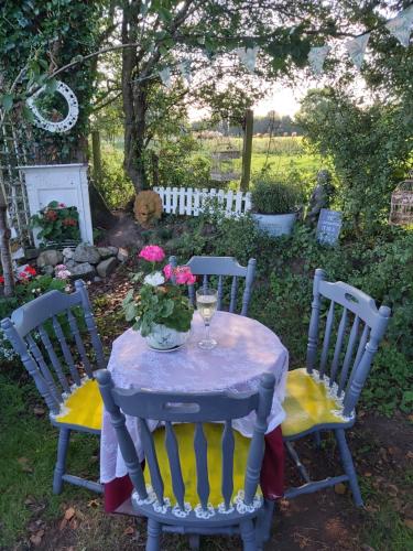 a table with a glass of wine and flowers on it at The Feathers Shepherds Hut in Áth Eascrach
