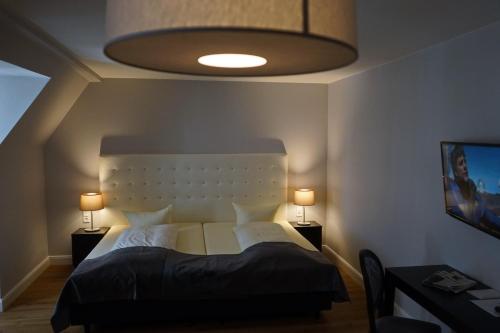 a bedroom with a large bed with a white headboard at Hotel Rheinischer Hof Bad Soden in Bad Soden am Taunus
