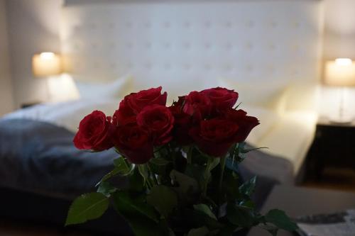 a bouquet of red roses in a vase on a table at Hotel Rheinischer Hof Bad Soden in Bad Soden am Taunus