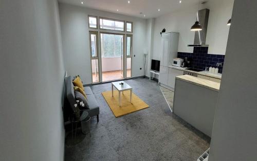 a kitchen and living room with a couch and a table at Doncaster City Centre Deluxe Whole Apartment sleeps 4 D2 in Doncaster