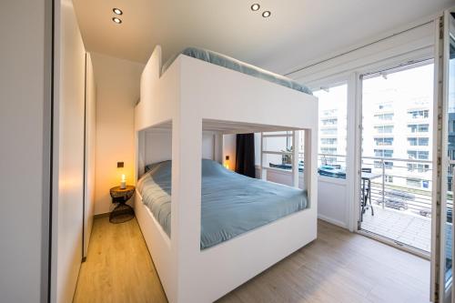 a bed in a white room with a large window at Apartment 2 bedrooms with magnificent seaview and free parking in Ostend