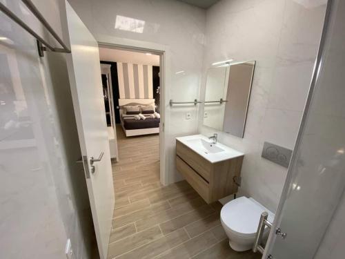 a bathroom with a toilet and a sink and a mirror at Cantinho do Sol (Estúdio Prata) in Lourinhã