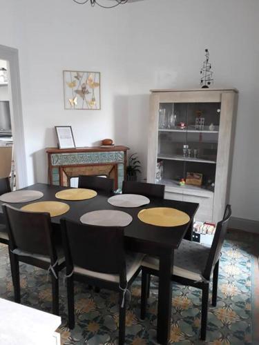 une salle à manger avec une table et des chaises noires dans l'établissement Maison de ville proche beauval avec parking, à Selles-sur-Cher