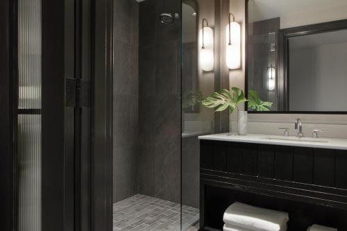 a bathroom with a sink and a glass shower at Kimpton Shane Atlanta by IHG in Atlanta