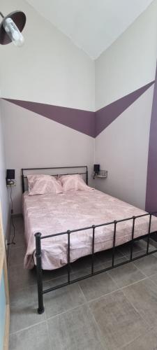 - une chambre dotée d'un lit avec un cadre noir dans l'établissement Maison de village en Provence avec terrasse de 33m2, à Saint-Roman-de-Malegarde