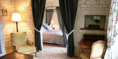 Schlafzimmer mit einem Bett, einem Tisch und Stühlen in der Unterkunft Château de Bournand B&B in Bournand
