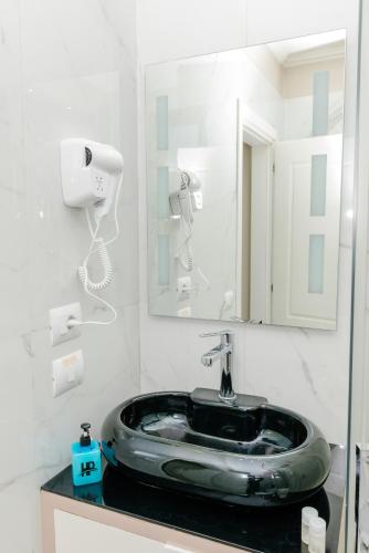 a bathroom with a sink and a mirror at Hotel Pazari & Apartments in Korçë