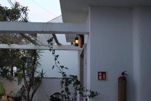 a light on the side of a white building at 5th Element Beach House Caparica in Costa da Caparica