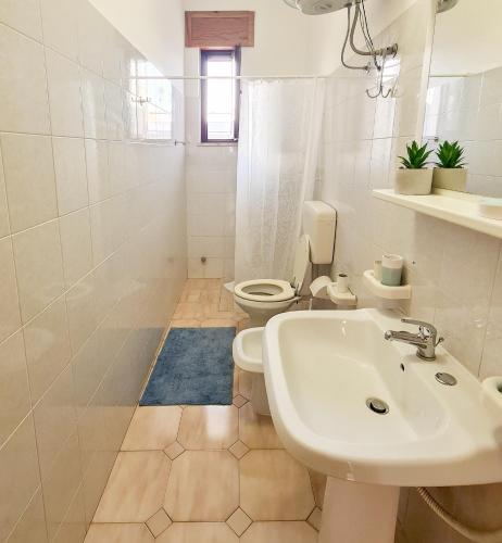 a white bathroom with a sink and a toilet at GAYA MARINA in Lido Marini