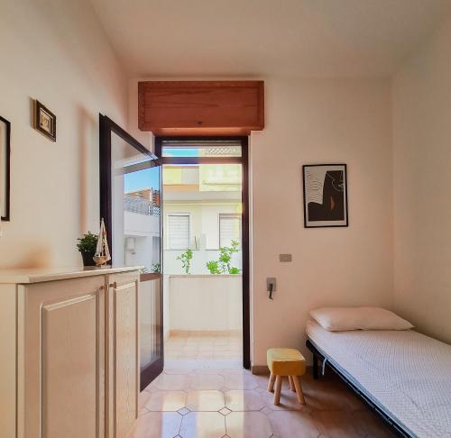 a room with a bed and a window and a bed and a door at GAYA MARINA in Lido Marini
