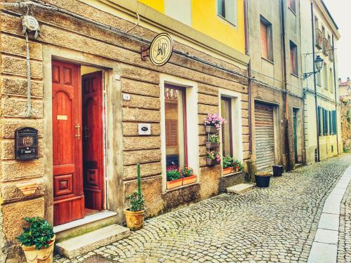 a building with a red door on a street at La Vecchia Posta B&B in Calangianus