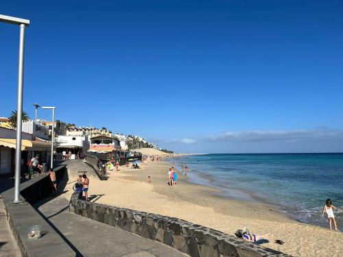 a group of people on a beach near the ocean at Heva Home in Tarajalejo