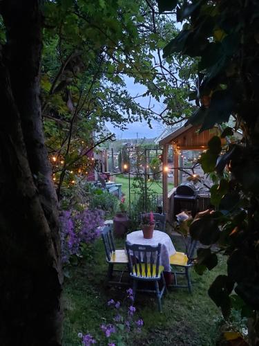 una mesa y sillas en un jardín por la noche en The Feathers Shepherds Hut, en Áth Eascrach
