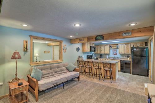 a living room with a couch and a kitchen at Expansive Cotter Cabin on White River with Deck! in Cotter