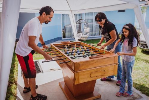 a family playing a game of foosball at Bungalow Jatun Mama in Ventanilla