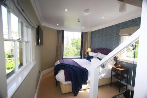 a small bedroom with a bed and a staircase at A Rare Georgian Crescent Residence with parking in Bath