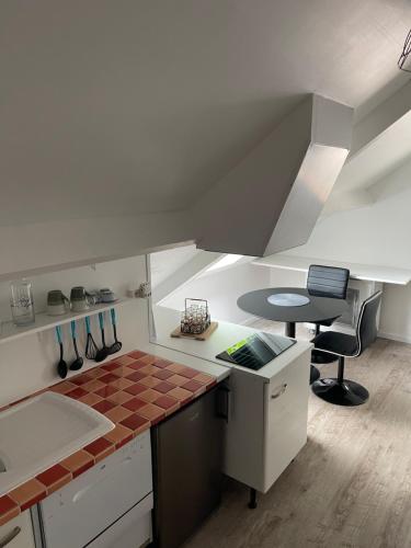 a kitchen with a counter top and a table at Les Gîtes de La Maison Bleue d'Estialescq in Estialescq
