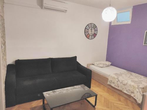 a living room with a black couch and a table at Apartment MM Split in Split