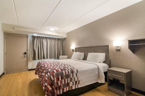 a hotel room with a bed and a window at Red Roof Inn Durham - Triangle Park in Durham