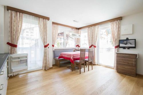 - une cuisine avec une table et des chaises dans la chambre dans l'établissement Apartment Romana, à Selva di Val Gardena