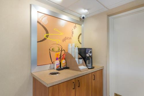 a room with a counter with a painting on the wall at Red Roof Inn Durham - Triangle Park in Durham