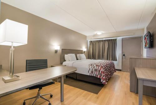 a hotel room with a bed and a desk at Red Roof Inn Durham - Triangle Park in Durham