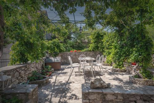 a patio with a table and chairs in a garden at Center apartment Golden Ray in Bol