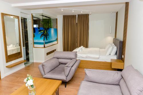 uma sala de estar com uma cama e um sofá em Hotel Pazari & Apartments em Korçë