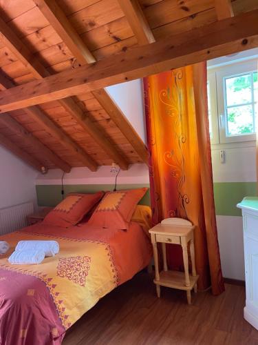 Les Gîtes de La Maison Bleue d'Estialescq في Estialescq: غرفة نوم مع سرير مع مظلة برتقال