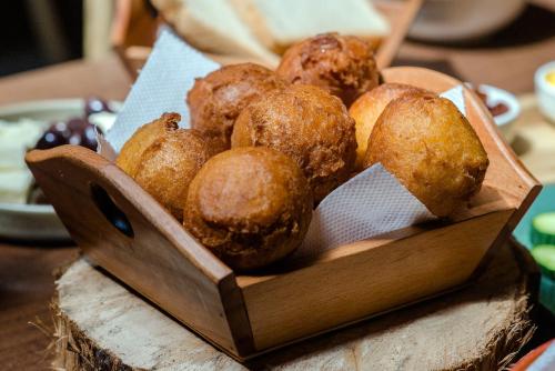 a wooden bowl of muffins sitting on a table at Hotel Pazari & Apartments in Korçë