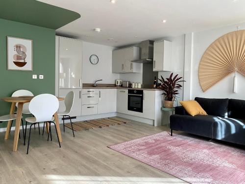 eine Küche und ein Wohnzimmer mit einer Couch und einem Tisch in der Unterkunft Modern apartment in central quiet York with free Parking - Contemporary new building in York