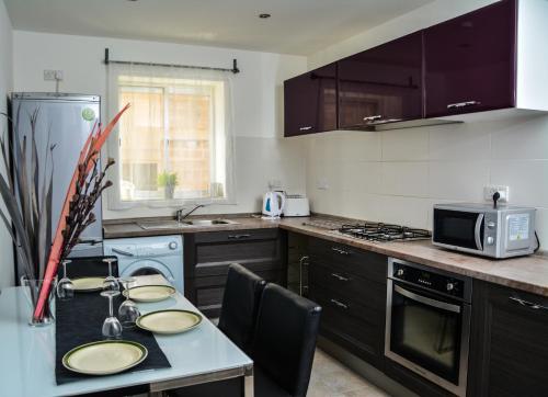 a kitchen with a table with plates on it at Pinewood in St Julian's
