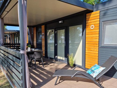 a screened porch with a table and chairs on a house at Sand & Relax Privlaka - Mobile home "Lavanda" in Privlaka