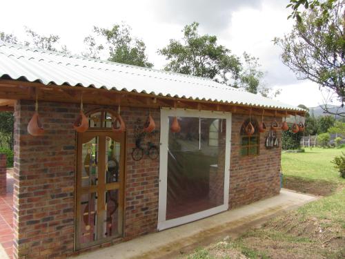 a brick building with a door and a window at Ecohotel, Finca Colinas y Senderos in Paipa