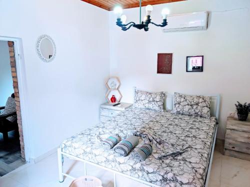 biała sypialnia z łóżkiem ze wzorzystym materacem w obiekcie Relax like the Old Days w mieście Kastanéa