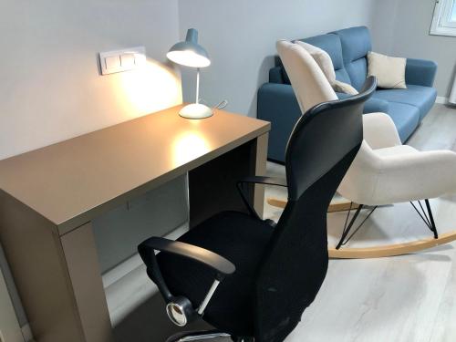 oficina con escritorio, silla y sofá en Apartamento Muralla, en Lugo