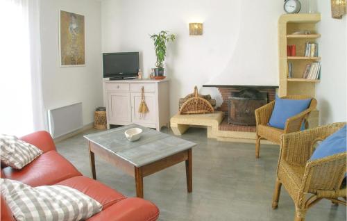a living room with a couch and a table and a fireplace at Lovely Home In Olonne Sur Mer With Wifi in Olonne-sur-Mer