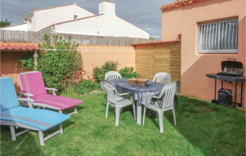 un patio avec une table et des chaises sur l'herbe dans l'établissement Lovely Home In Olonne Sur Mer With Wifi, à Olonne-sur-Mer