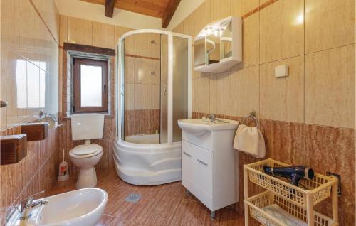 a bathroom with a sink and a toilet and a tub at Lovely Home In Visnjan With Outdoor Swimming Pool in Višnjan