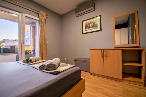 a bedroom with a bed and a dresser and a window at Apartments Hudovernik in Baška Voda