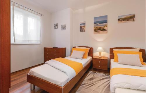 two twin beds in a room with a window at Amazing Apartment In Labin With Kitchen in (( Hrvatini ))