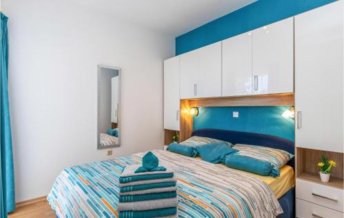 a bedroom with a bed with a blue headboard at Cozy Apartment In Crikvenica With Wifi in Crikvenica