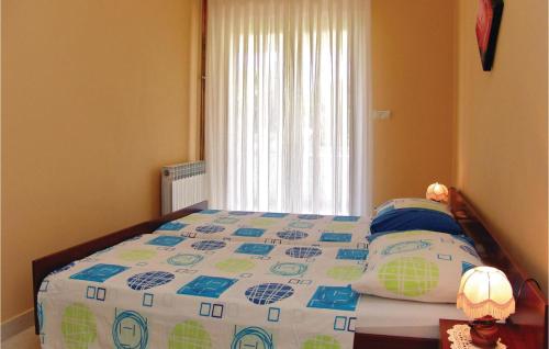 een slaapkamer met een bed met een dekbed en een raam bij Pet Friendly Apartment In Porec With Wifi in Poreč