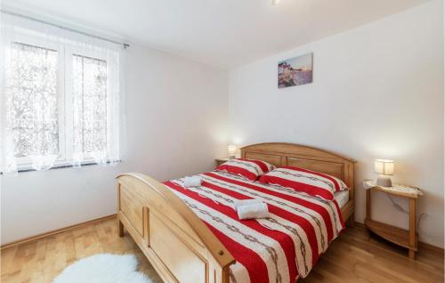a bedroom with a bed with a red and white blanket at Lovely Apartment In Pavicini With Wifi in Pavicini