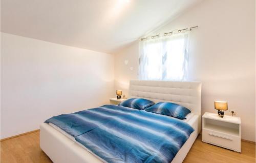 ein weißes Schlafzimmer mit einem großen Bett mit blauer Bettwäsche in der Unterkunft Awesome Apartment In Sv,petar U Sumi With Wifi in Pamići