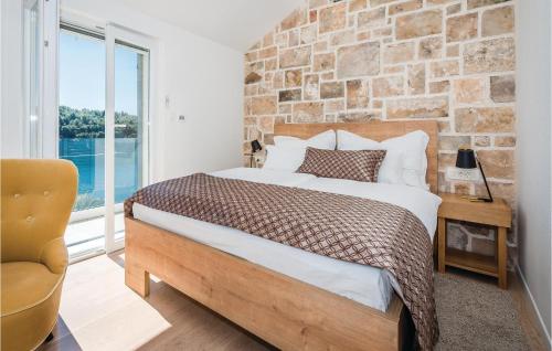 a bedroom with a bed and a brick wall at Cozy Home In Milna With House Sea View in Milna